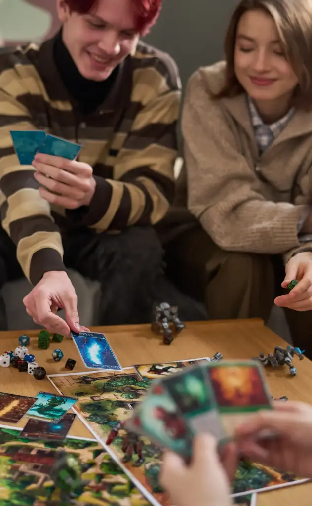 Jongvolwassenen die deelnemen aan een bordspeltoernooi en een fantasiekaartspel met dobbelstenen en miniaturen spelen in Nederland.